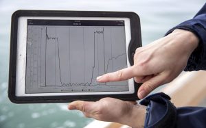 Researcher Aubrey Ellertson points to data recorded on a test drop of the Connectivity Temperature and Depth sled. (Robin Lubbock/WBUR)